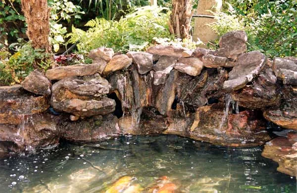 Natural stone waterfall feeding a koi pond